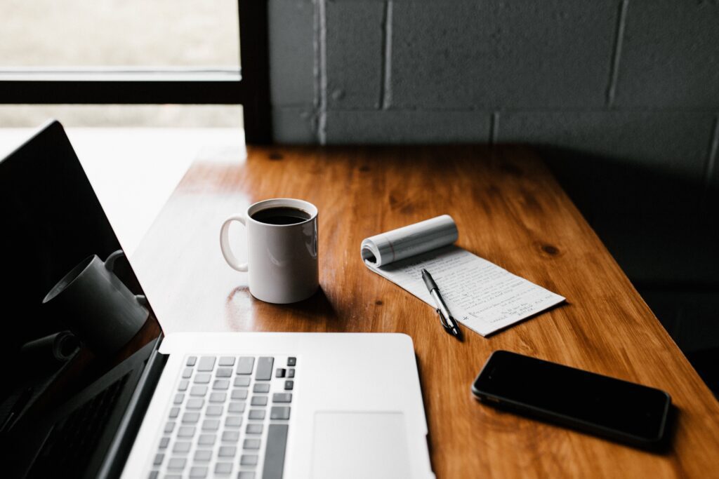 laptop, coffee and a notepad.